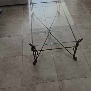 שולחן זכוכית עם רגלי מתכת על רצפה אפורה