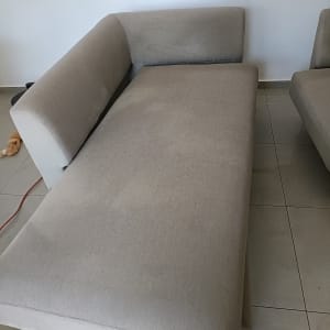 ניקוי ספה עם צינור על רצפת אריחים