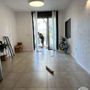 חדר ריק עם אדם ליד חלון, סולם, קופסאות ואופניים