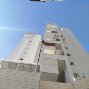 אדם מבצע עבודה בגובה על בניין