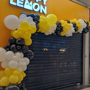 קישוט בלונים על חנות סגורה עם שלט Happy Lemon