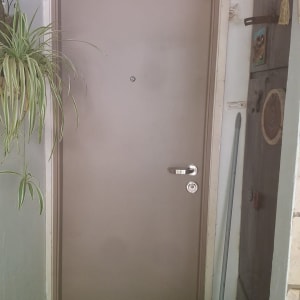 דלת חומה עם ידית ומטאטא בצד