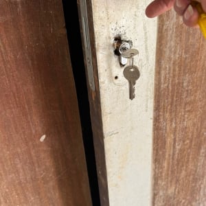 יד מחזיקה מפתח בדלת עץ עם מנעול