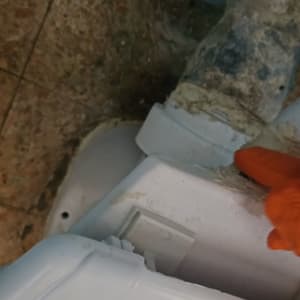 תמונה של צינור ותיקון עם כפפה כתומה