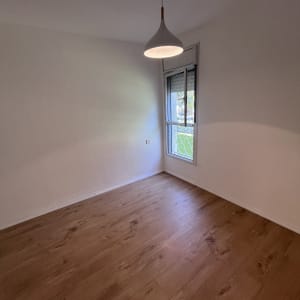 חדר ריק עם רצפת עץ נקייה וקירות לבנים