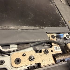 חלקי מחשב נייד עם ברגים וחיבורים פנימיים