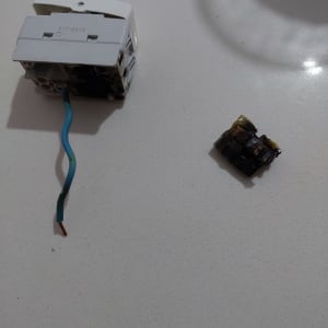 שקע חשמלי עם חוט חשמל חשוף וחלקים שרופים