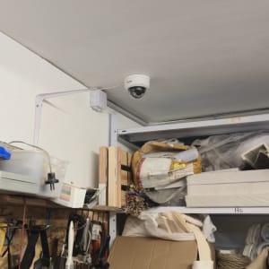 מצלמת אבטחה מותקנת על תקרה במחסן עם כלים וחומרים שונים