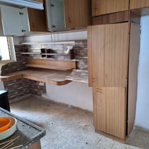 ארונות מטבח פתוחים עם מדפים ריקים וקערות על השיש