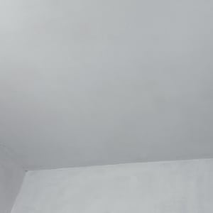 קיר ותקרה צבועים בלבן עם חלון קטן