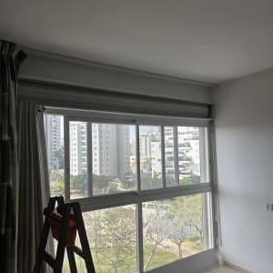 סולם ליד חלון עם תריסים פתוחים ונוף עירוני