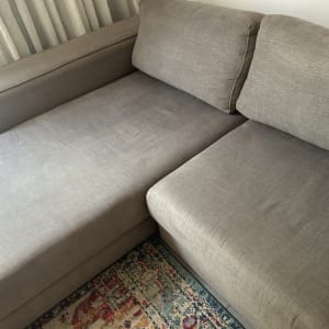 ספה אפורה נקייה ליד וילון