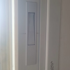 ידית תריס לבנה על מסגרת חלון