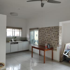 חדר עם שולחן עץ, בקבוקי צבע ומברשת