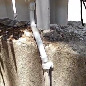 צינור לבן מחובר לגדר בטון