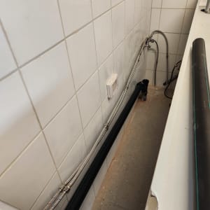 צנרת מתכת ליד קיר אריחים לבנים