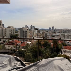 מעקה זכוכית במרפסת עם נוף לעיר