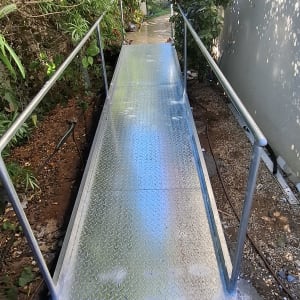 שביל מתכת עם מעקה ליד בית וגינה