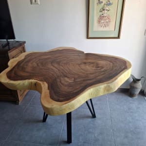 שולחן עץ עם רגליים שחורות על רצפת אריחים אפורה