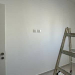 סולם ודלי בחדר עם קיר צבוע