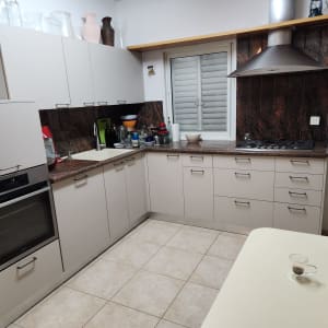 מטבח מודרני עם ארונות לבנים וכיריים גז