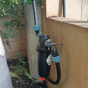 מסנן מים מותקן על קיר עם צינורות מחוברים