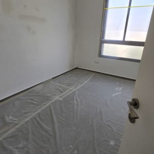 חדר עם קירות צבועים ויריעות מגן על הרצפה