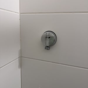 חיבור צינור מים על קיר אריחים לבנים