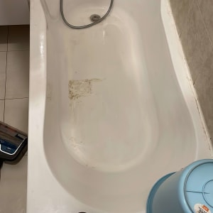 אמבטיה עם דלי כחול ובקבוק על הרצפה