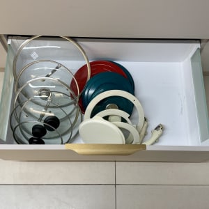 מכסי סירים מאורגנים במגירה במטבח