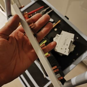 יד מחזיקה רכיב חשמלי עם כלים ברקע