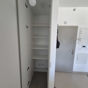 ארון פתוח עם מדפים ליד דלת כניסה