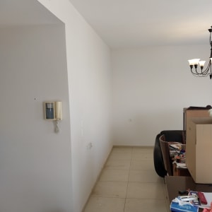 קיר צבוע עם דלי צבע וכלים על שולחן