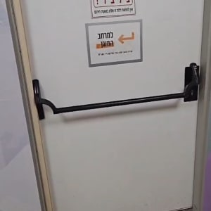 דלת פלדה ליציאת חירום ומרחב מוגן עם ידית בהלה שחורה