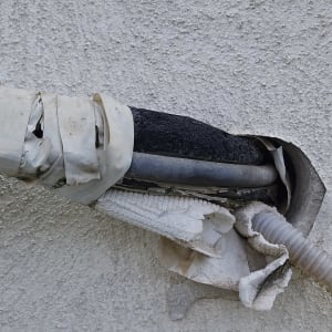 צינור עם נזילה עטוף בסרט דביק על קיר