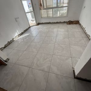 ריצוף חדש בחדר עם חלון ודלת למרפסת