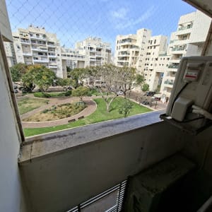 רשת יונים מותקנת על מרפסת עם נוף לבניינים