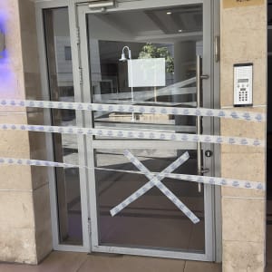 דלת זכוכית עם סרטי אזהרה בכניסה לבניין