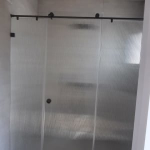 מקלחון עם דלתות זכוכית מחוסמת בחדר אמבטיה