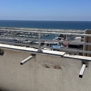 מרפסת עם נוף לים ומעקה מתכת
