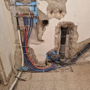 צינורות מים וחשמל בקיר במהלך שיפוץ