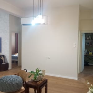 קיר לבן חלק עם תאורה תלויה מעליו