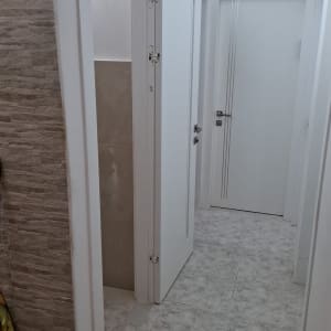 מסדרון עם דלתות לבנות וריצוף קרמיקה