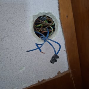 חוטי חשמל צבעוניים יוצאים מקיר עם חיבורי חשמל