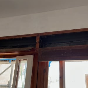 חלון עץ פתוח עם מסגרת עליונה חשופה