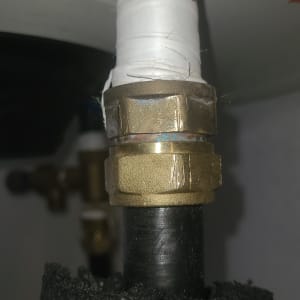 חיבור צינור עם סרט איטום לבן ומחבר מתכת