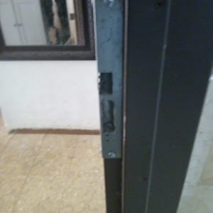 תקריב של מנעול בדופן דלת כחלק מעבודת תיקון דלת