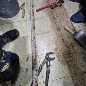 כלי עבודה של אינסטלטור, כולל צינור חלוד ומפתח צינורות