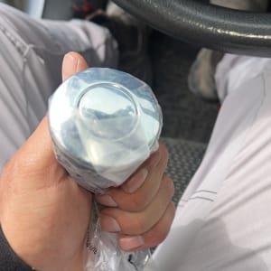 יד מחזיקה חפץ עגול בתוך רכב