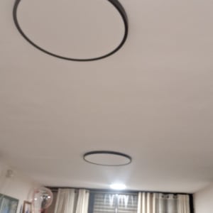 תאורה עגולה בתקרה בסלון עם וילונות